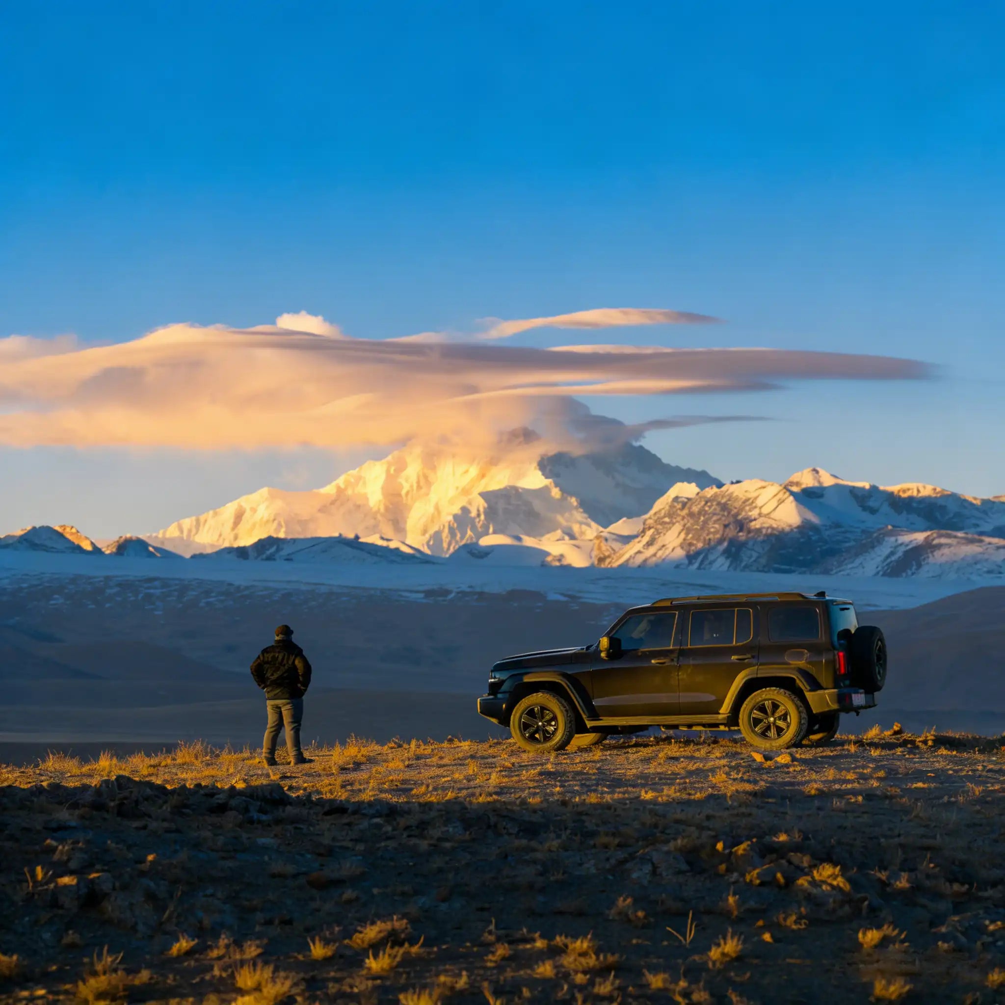 A journey of discovery: traveler and car in the high mountains at dawn
